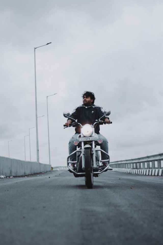 cool brutal man riding motorbike along road