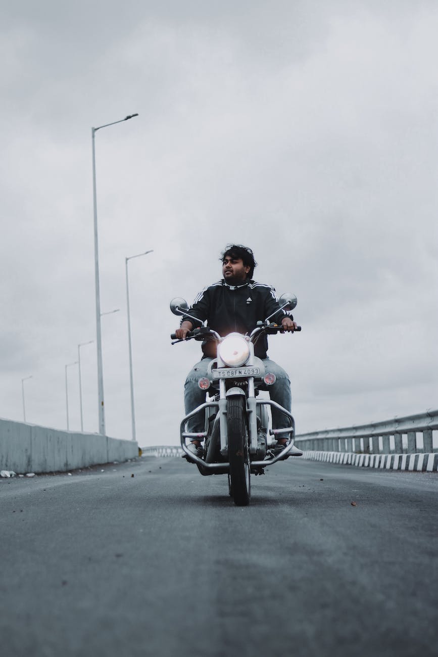 cool brutal man riding motorbike along road